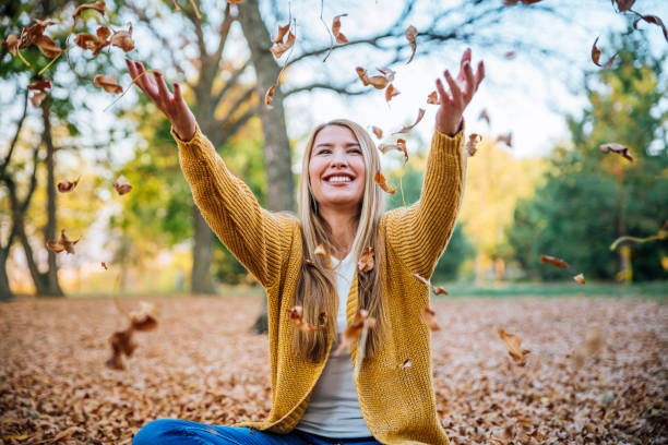 alt="a girl throwing leaves up in the air"
